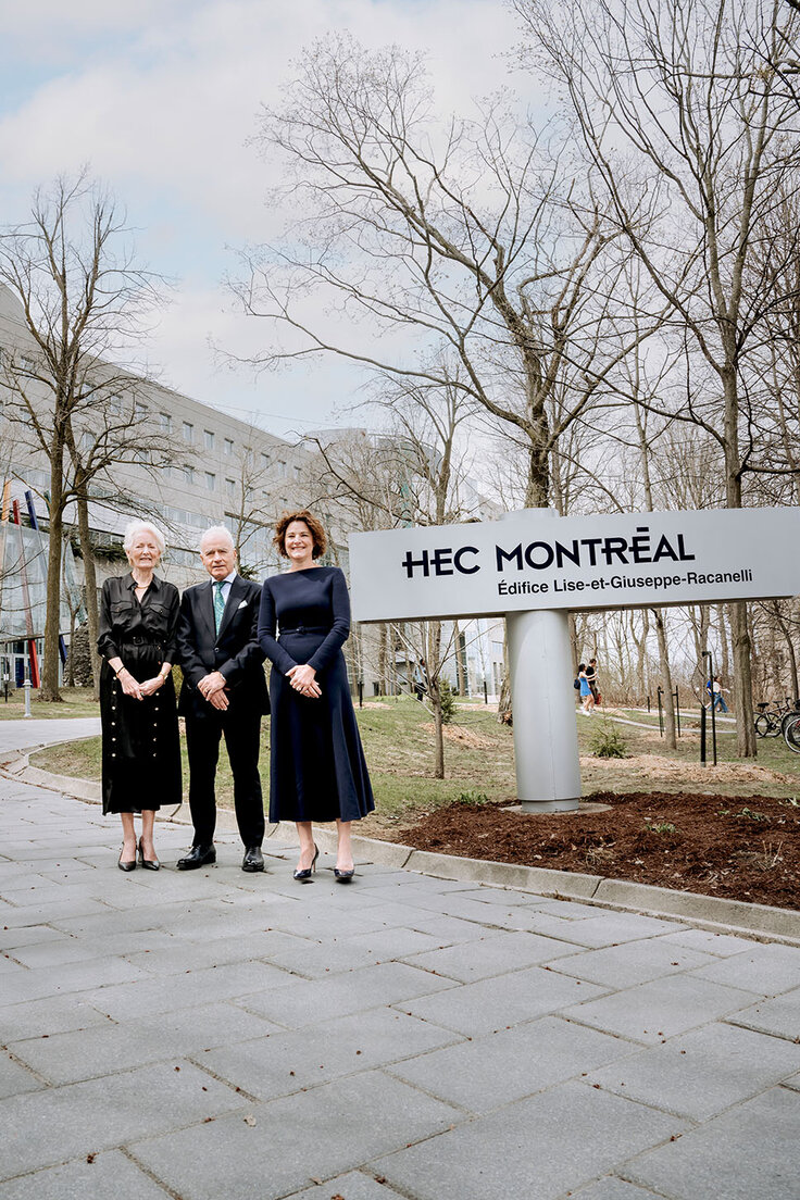 Three members of the Racanelli family stand together beside a campus sign outside HEC Montréal.