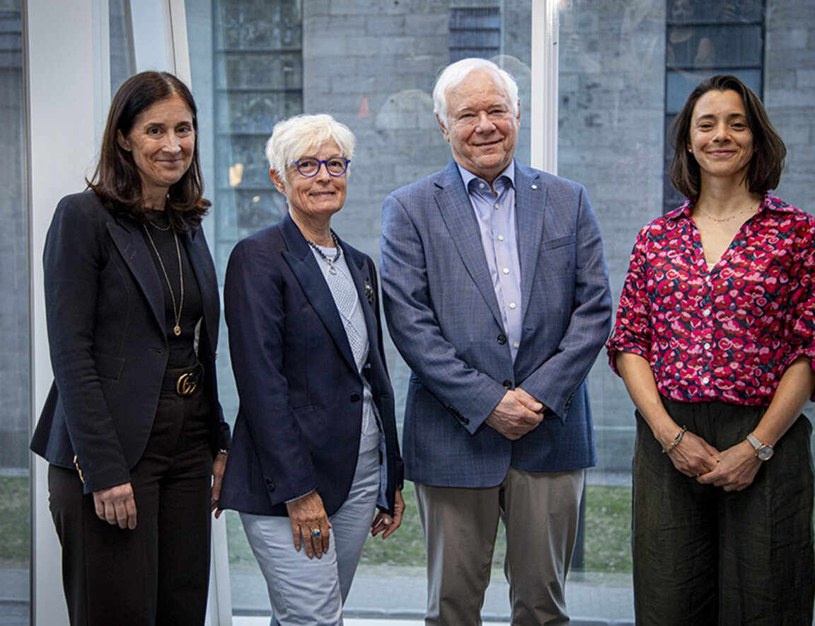 Les personnes lauréates des prix de gestion culturelle et deux personnes représentant HEC Montréal se tiennent debout devant une grande fenêtre vitrée.