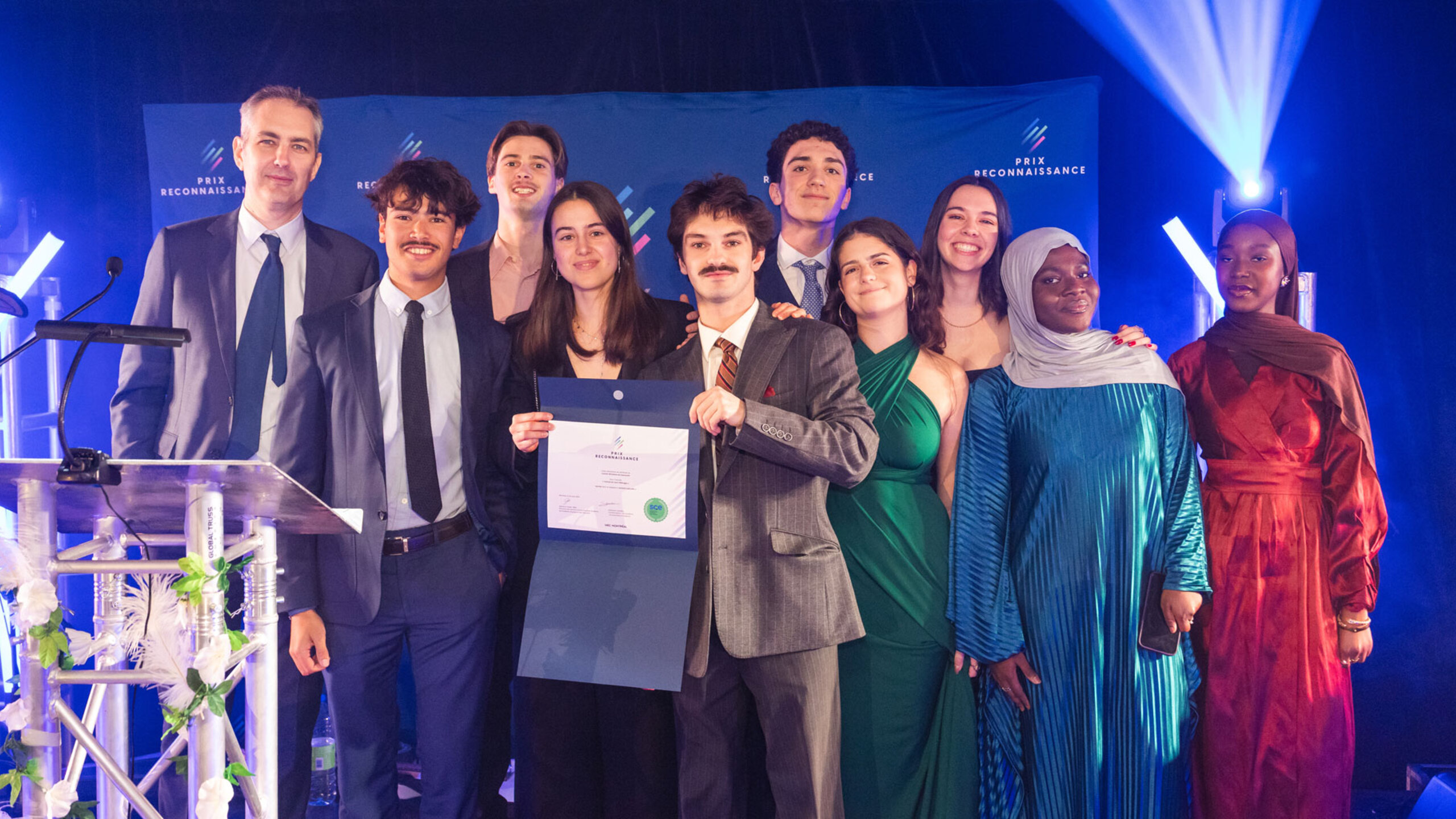 Groupe de lauréates et lauréats posant ensemble lors de la soirée du Gala des Prix reconnaissance, sur une scène éclairée, tenant des certificats et des trophées.