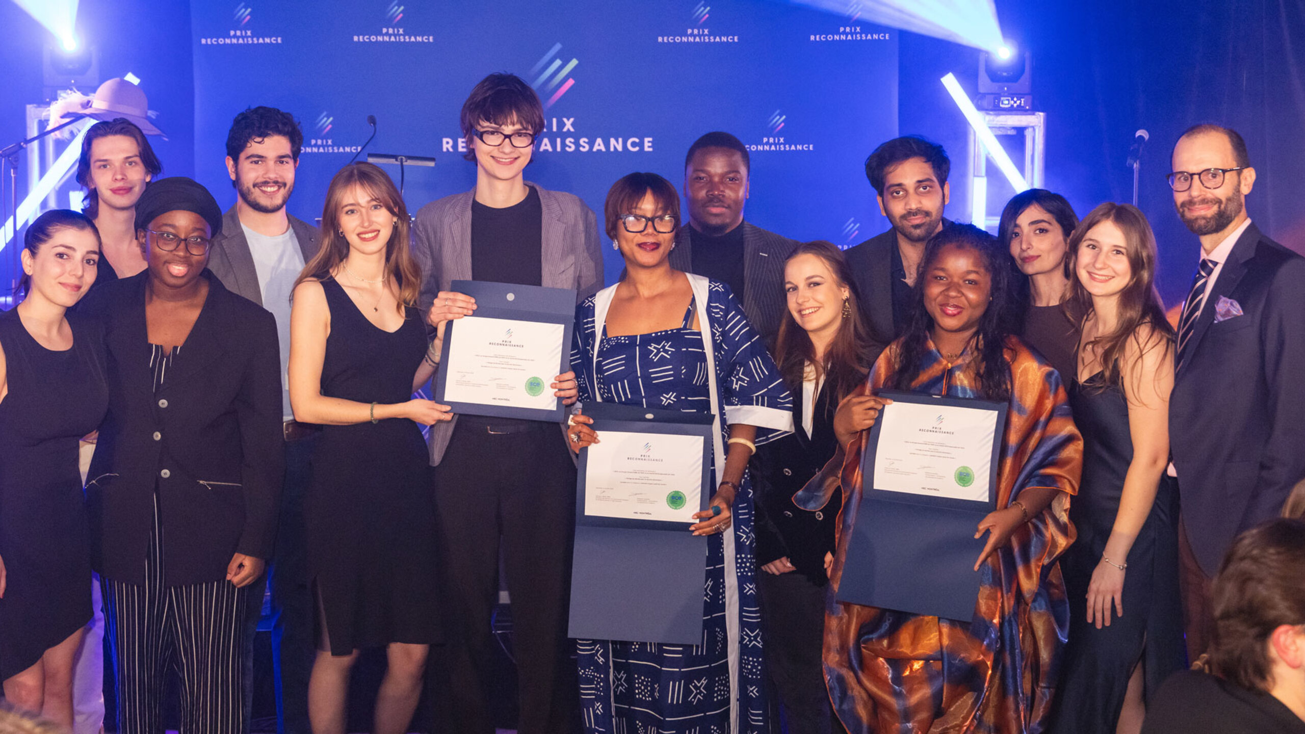 Groupe de lauréates et lauréats posant ensemble lors de la soirée du Gala des Prix reconnaissance, sur une scène éclairée, tenant des certificats et des trophées.