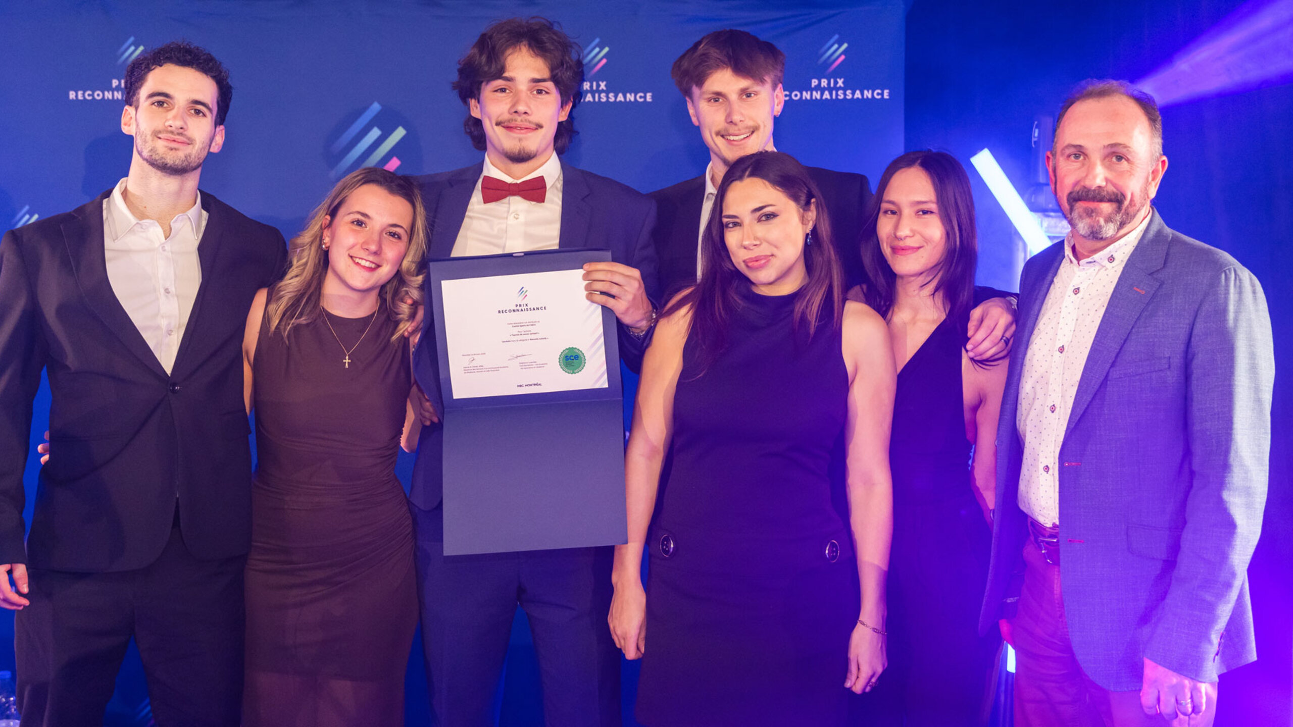 Groupe de lauréates et lauréats posant ensemble lors de la soirée du Gala des Prix reconnaissance, sur une scène éclairée, tenant des certificats et des trophées.