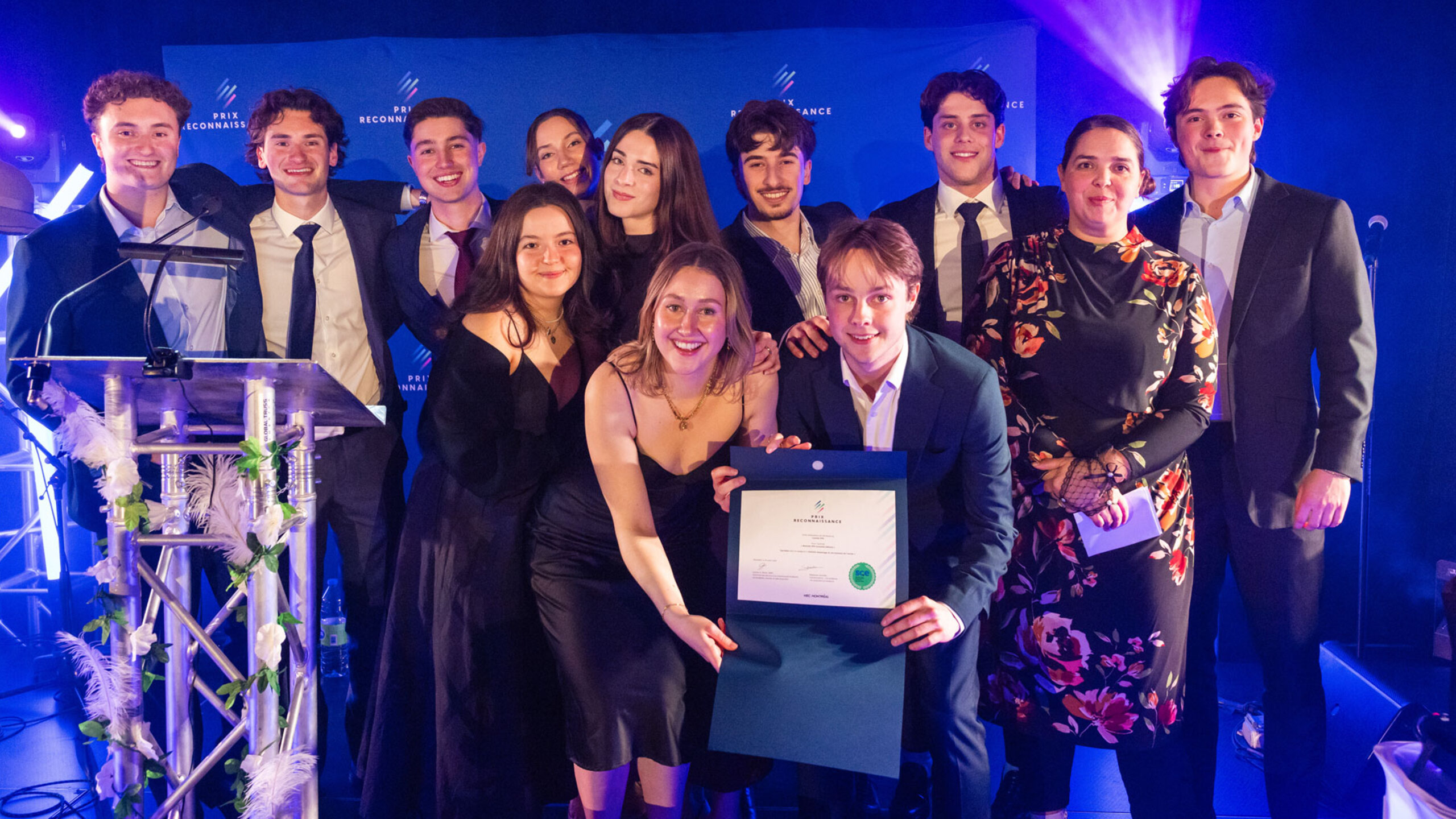 Groupe de lauréates et lauréats posant ensemble lors de la soirée du Gala des Prix reconnaissance, sur une scène éclairée, tenant des certificats et des trophées.