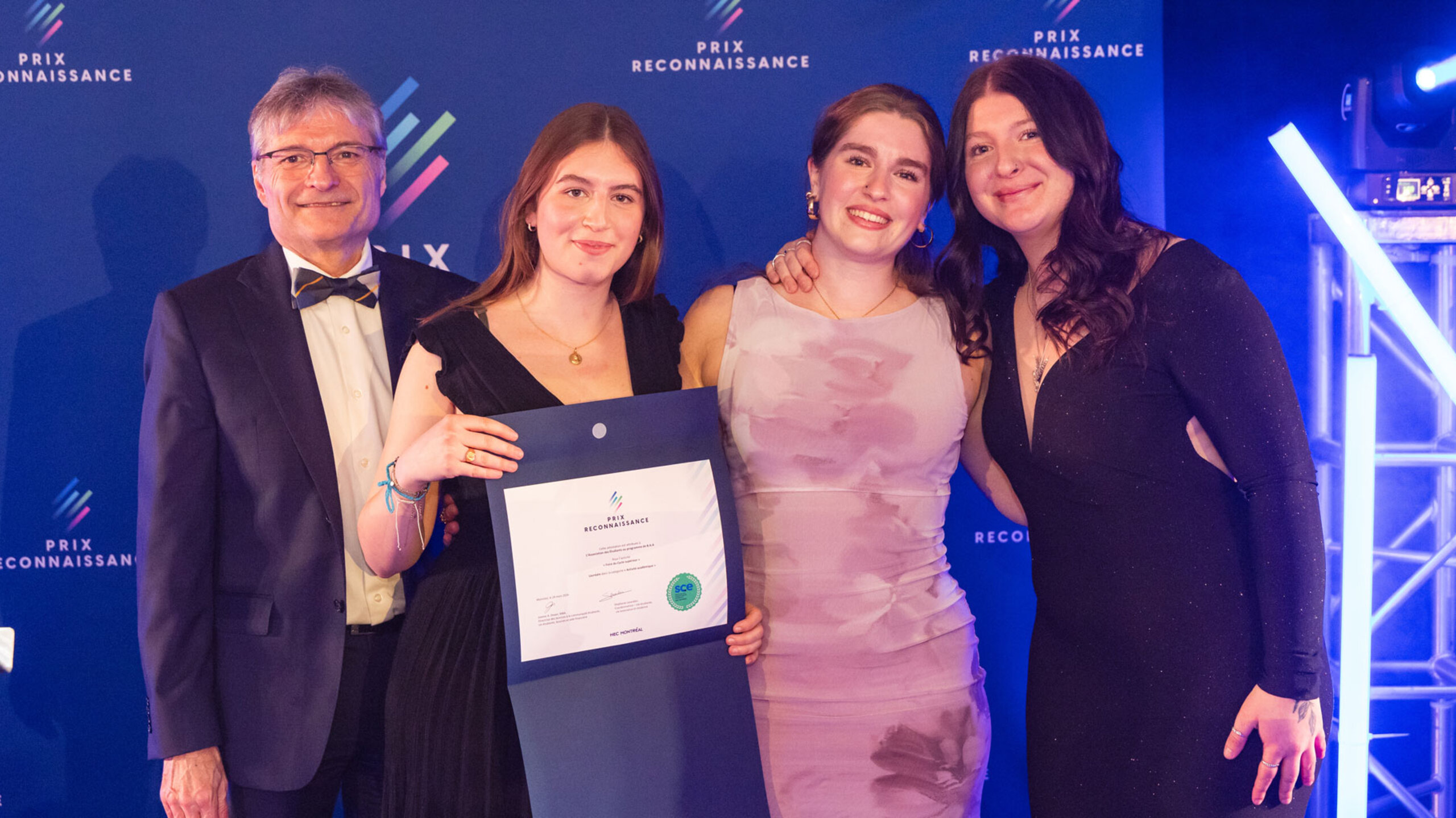 Groupe de lauréates et lauréats posant ensemble lors de la soirée du Gala des Prix reconnaissance, sur une scène éclairée, tenant des certificats et des trophées.
