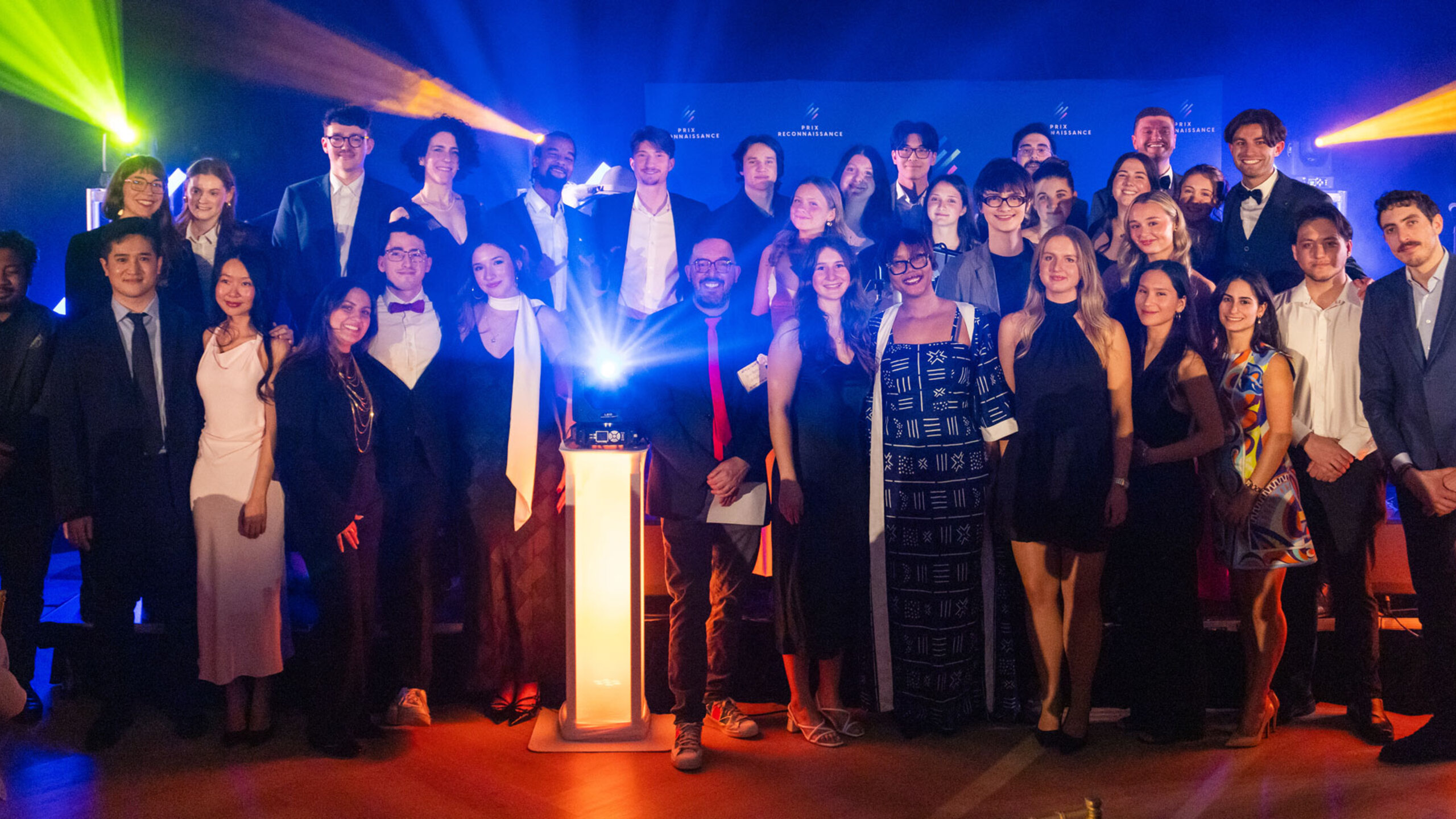 Groupe de lauréates et lauréats posant ensemble lors de la soirée du Gala des Prix reconnaissance, sur une scène éclairée, tenant des certificats et des trophées.