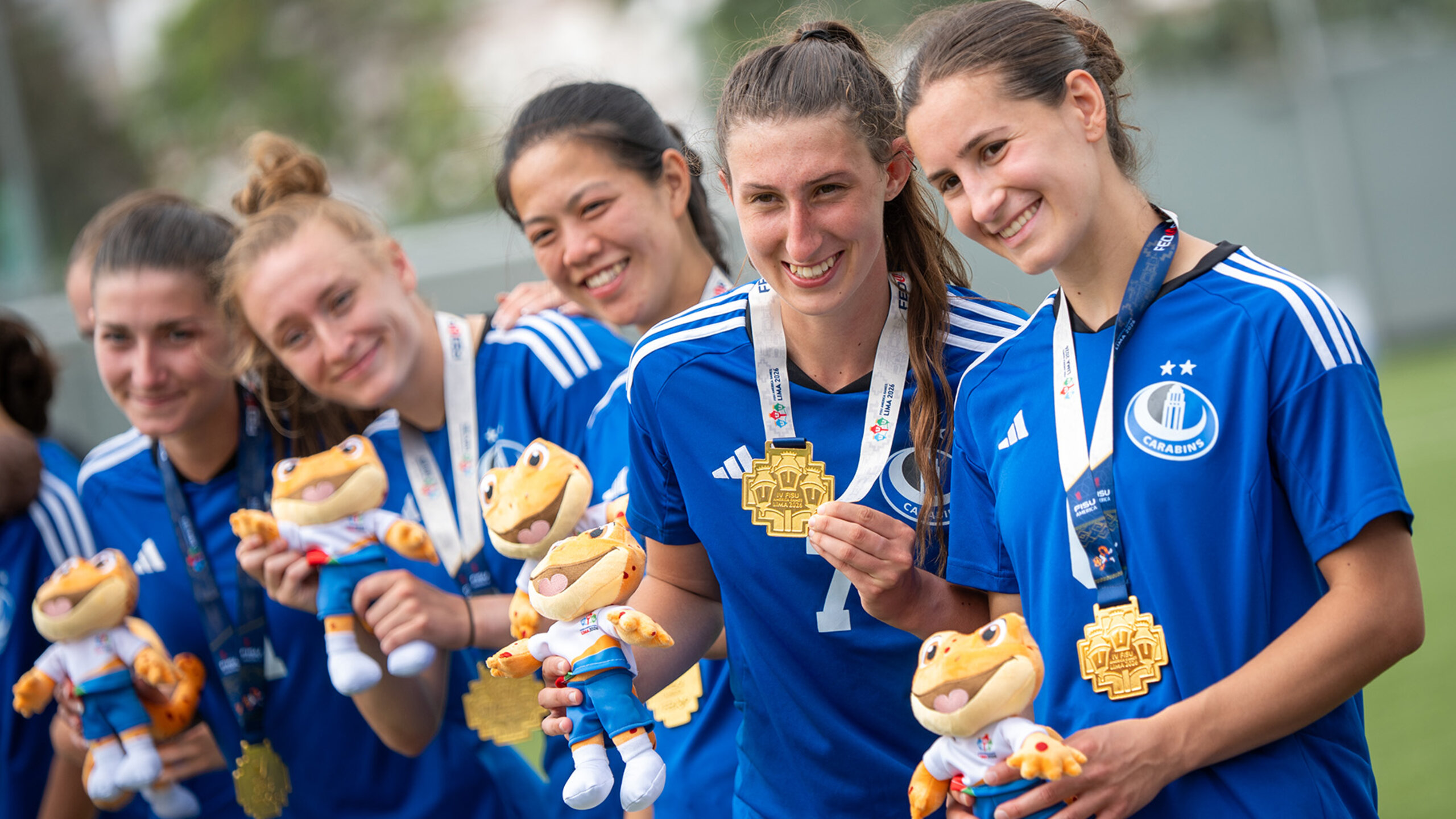 Carabins athletes wearing gold medals and holding the event’s mascots after the final of the FISU Championship of the Americas.