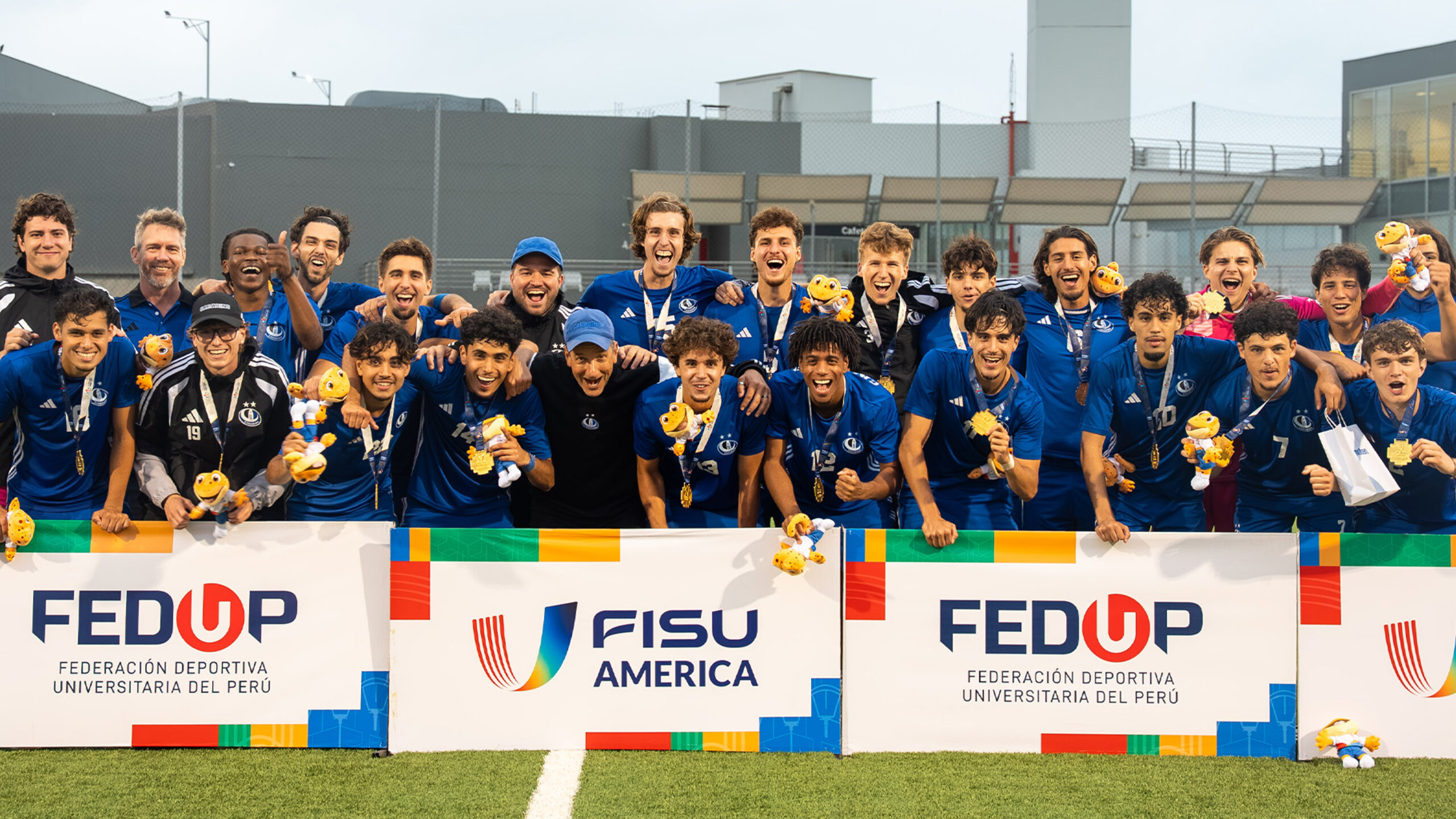 Carabins soccer players wearing gold medals and holding the event’s mascots after the FISU Championship of the Americas.