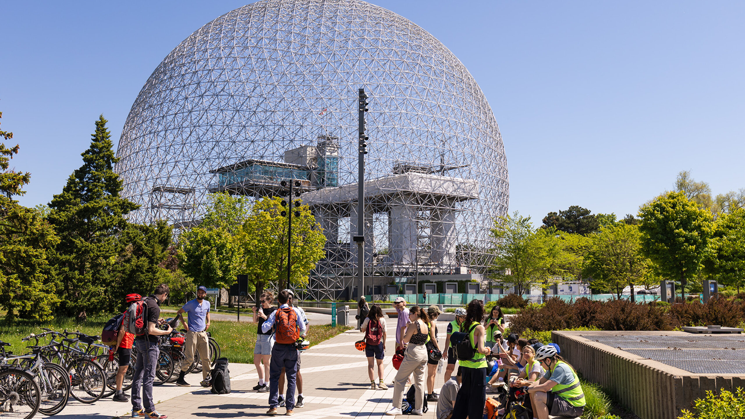 Groupe d'étudiantes et d'étudiants à vélo participant à une activité pédagogique devant la Biosphère de Montréal.
