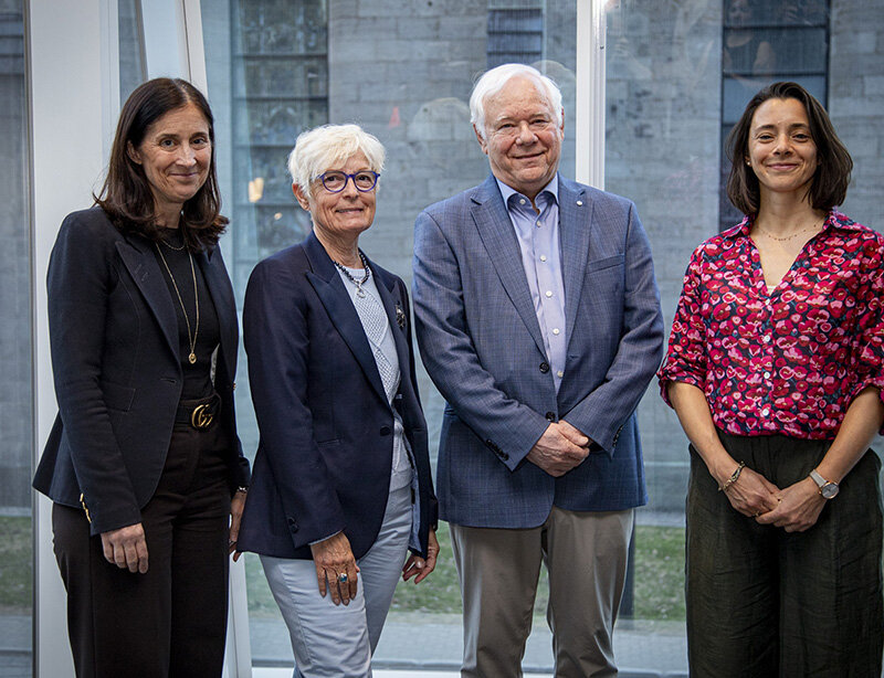 Les personnes lauréates des prix de gestion culturelle et deux personnes représentant HEC Montréal se tiennent debout devant une grande fenêtre vitrée.