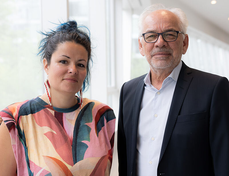 Marine Agogué et Ghislain Picard, debout côte à côte dans un corridor lumineux avec de grandes fenêtres. 