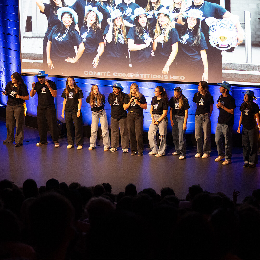 A group of students on stage in front of an audience gathered in the amphitheatre.