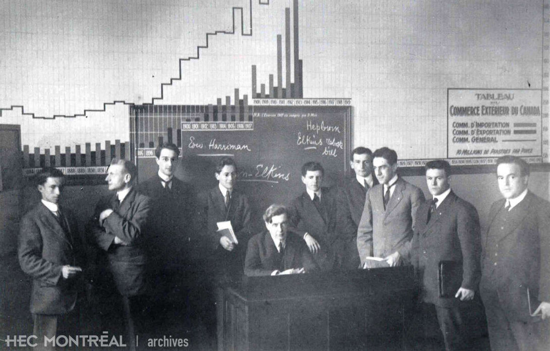   Description : Édouard Montpetit et les étudiants de la troisième promotion de HEC dans une salle de classe. Date : 1915 Crédit photo : Photographe inconnu Cote archivistique : P005/XPH,0010