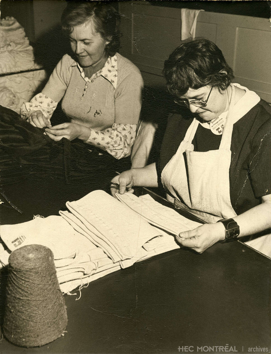   Description : Deux travailleuses de Tricofil à leur table de travail. Date : Inconnue Crédit photo : Photographe inconnu Cote archivistique : P008/XPH,0002
