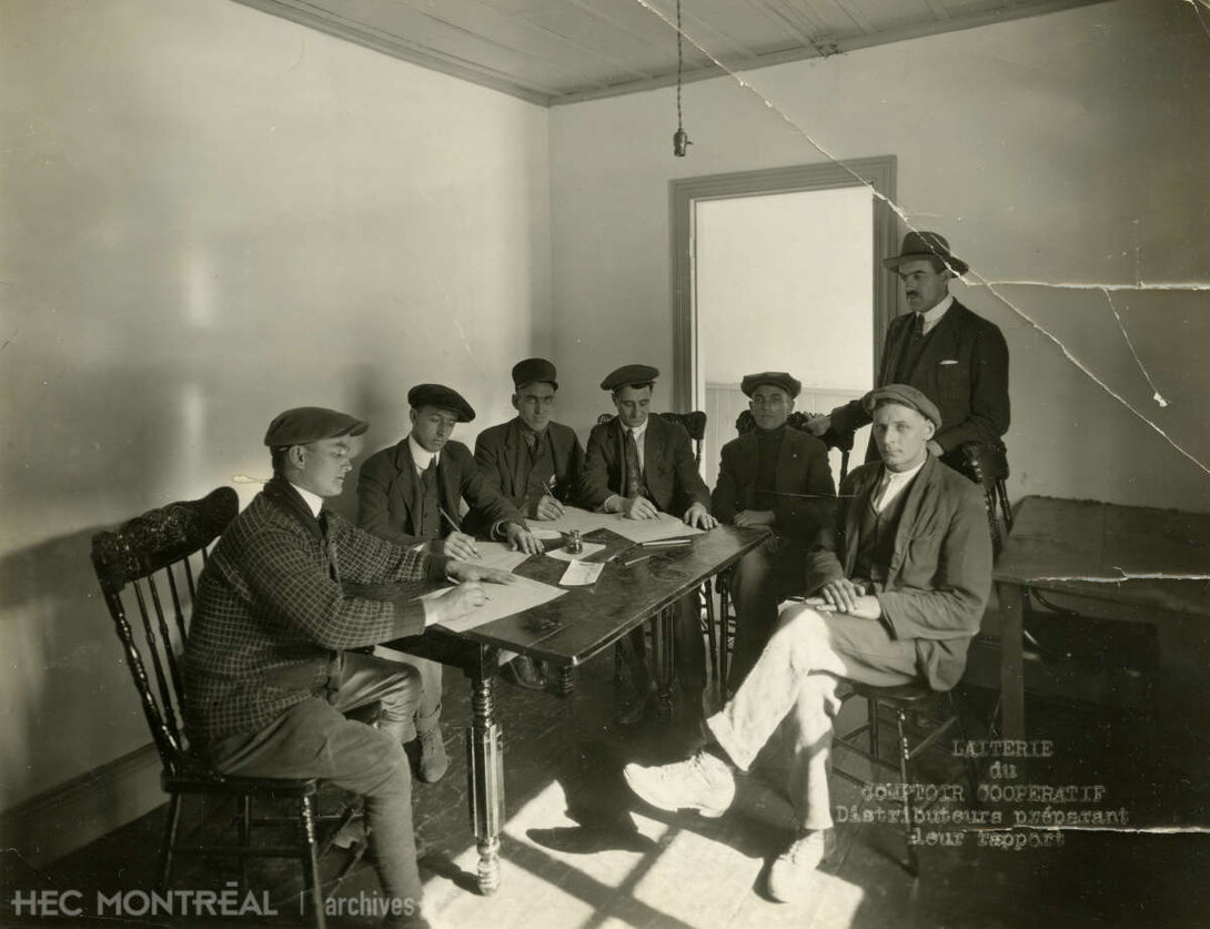   Description : Des distributeurs de lait du Comptoir coopératif de Montréal préparant leur rapport. Date : [entre 1912 et 1922] Crédit photo : Henri Fortier Photographie Cote archivistique : P061/X,0005